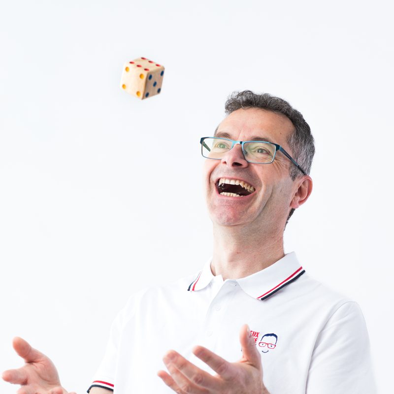 Frédéric lance un dé en l’air en riant