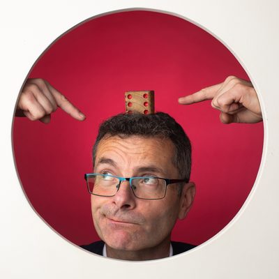 Frédéric, un dé en équilibre sur la tête, désigné par deux mains