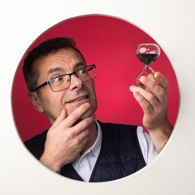 Frédéric observe un sablier, l’air songeur